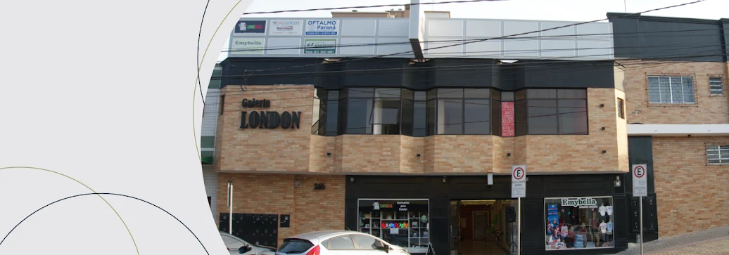 Fachada real da Galeria London na Rua César Carelli, com o nome da galeria na parede de tijolos e a entrada das lojas